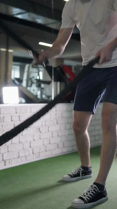 Athletic man training with ropes during crossfit workout in gym. Vídeos de archivo 302806584