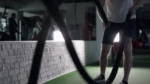 Athletic man training with ropes during crossfit workout in gym. Stock Footage 302983070