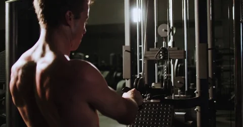 Athletic man uses a weight machine/exercise equipment Stock Footage 83191182