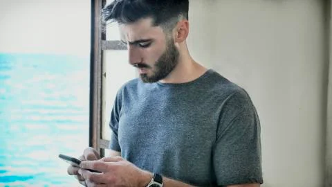 Athletic man using cell phone to type message Stock Photos