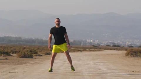Athletic man warming up and stretching before workout in nature Video stock 132166382
