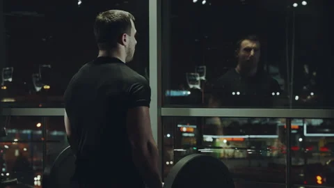 Athletic man working out with barbell and looking out window Stock Footage 148333551