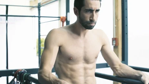 Athletic man working out on dip bars at the gym Stock Footage 127436980