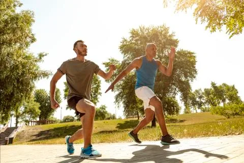 Athletic men jogging in the park. Stock Photos