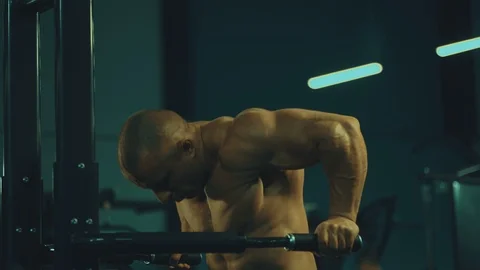 Athletic men pumping up muscles push-ups on uneven bars Video stock 118775909