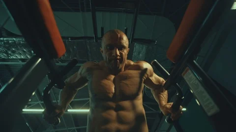 Athletic men pumping up muscles push-ups on uneven bars Видео 118776206