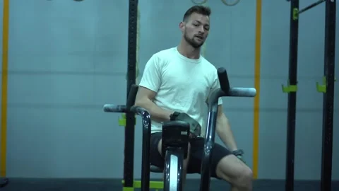 Athletic middle aged man training on air resistance bike. Video stock 131028329