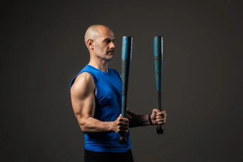 Athletic, middle aged man training with clubbells, studio background Stock Photos