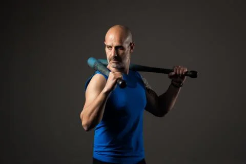 Athletic, middle aged man training with clubbells, studio background Stock Photos