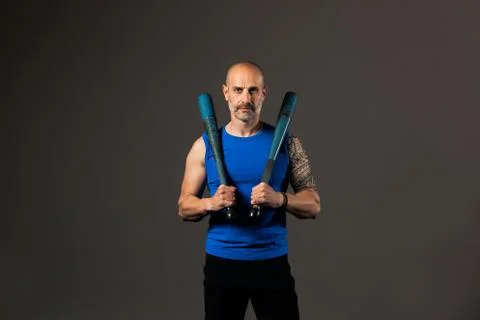 Athletic, middle aged man training with clubbells, studio background Stock Photos