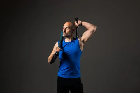 Athletic, middle aged man training with clubbells, studio background Stock Photos