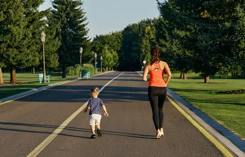 Athletic mom with her son doing morning jog in park Foto stock