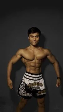 Athletic Muscular Man Posing in Studio with Defined Abs and Fighter Shorts Stock Photos
