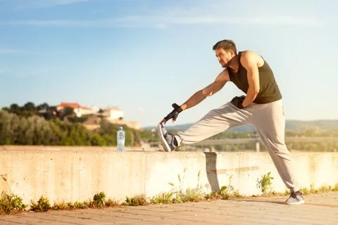 Athletic runner doing stretching exercise Stock Photos