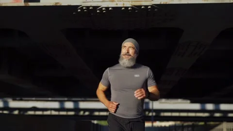 Athletic senior running down bridge road Stock Footage 135462185