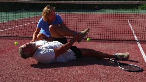 Athletic senior tennis player suffers leg injury on the court while his wif.. Stock Footage 290353003