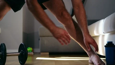 Athletic slim man is stretching in dark room. Footage FHD Stock Footage 147044709