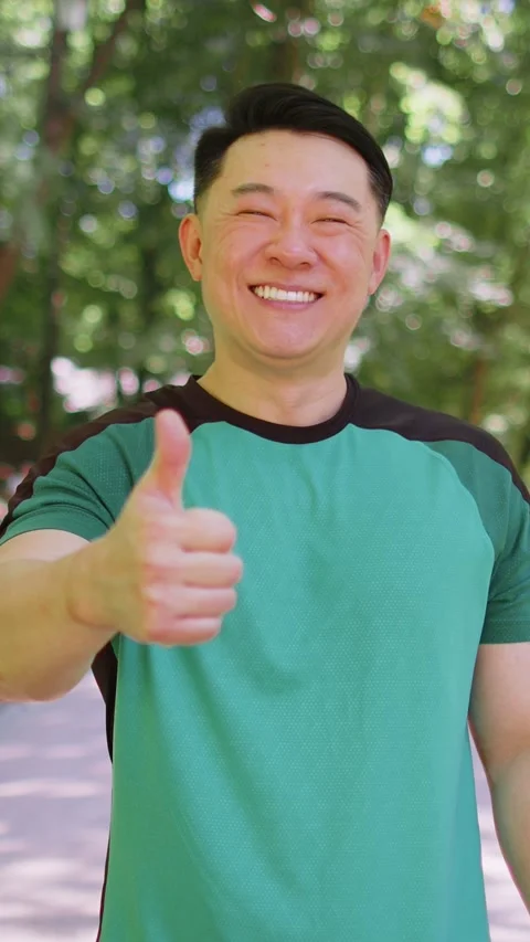 Athletic smiling runner fit man, happy about marathon achievement showing thumb Stock Footage 333459132