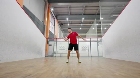 Athletic squash player hits ball with racket quickly Stock Footage 220979561