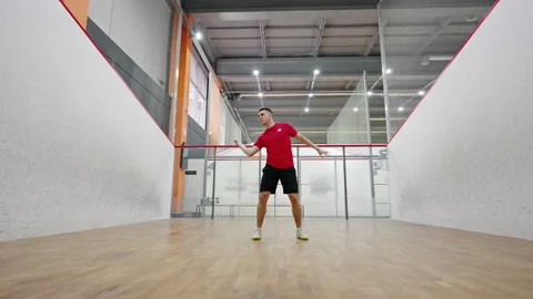 Athletic squash player hits ball with racket quickly Stock Footage 221230650