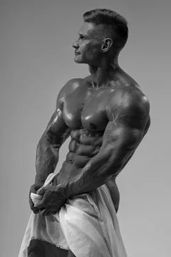 Athletic strong man posing in a studio white cloth in an original way Stock Photos
