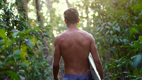 Athletic Surfer guy with surfboard walk in tropical jungle Stock Footage 108568984