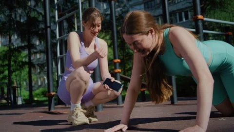Athletic Twins Doing Push-Ups and Encouraging Each Other Outdoors Vidéo 336961169