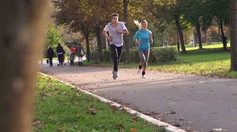 Athletic Urban Joggers Run Through Busy Park Stock Footage 42161980