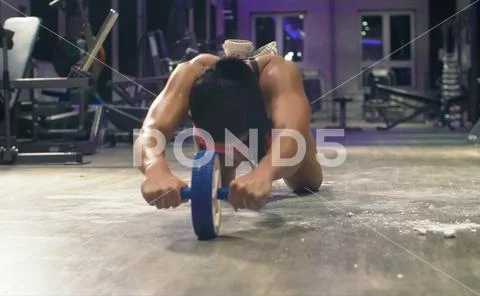 Athletic woman doing ab wheel exercises. Bodybuilding concept. Stock Photos