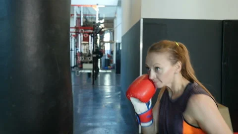 Athletic woman doing exercise to box and practice with punching bag. Slow motion Video stock 106672631