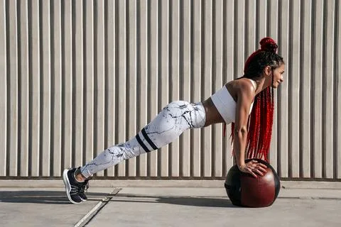 Athletic woman doing exercise push ups with med ball. Strength and motivati.. Stock Photos