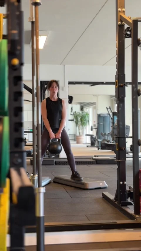 Athletic woman doing squat exercise while holding heavy kettlebell Stock-Footage 336271933