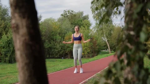Athletic woman jumping rope during outdoor workout 스톡 동영상 334741953