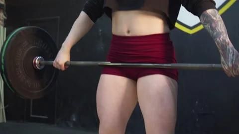 An athletic woman is lifting a barbell above her head Stock Footage 155907053