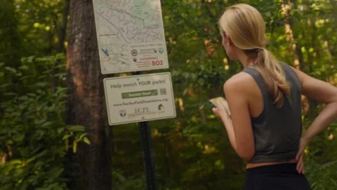 Athletic woman looking at trail map Stock Footage 250017765