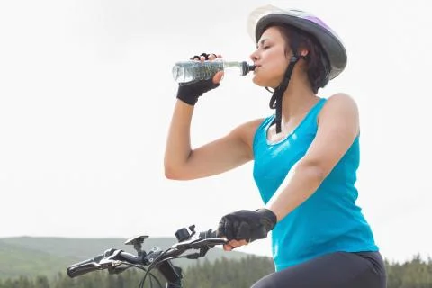 Athletic woman on mountain bike drinking water Stock Photos