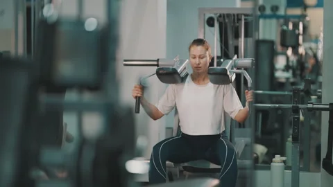 Athletic woman performing squats on a hack squat machine Stock Footage 332483405