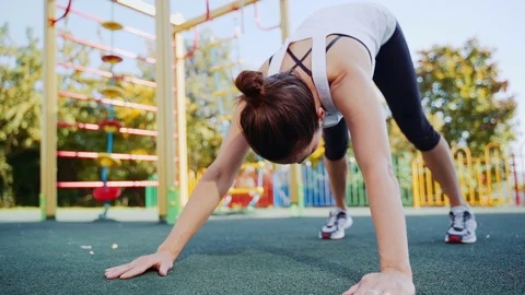 Athletic woman performs stretching after exercise in the fresh air. The girl Stock Footage 119354548