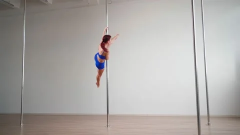 Athletic woman pole dancer performs acrobatic stunts with stretching elements Stock Footage 168312846