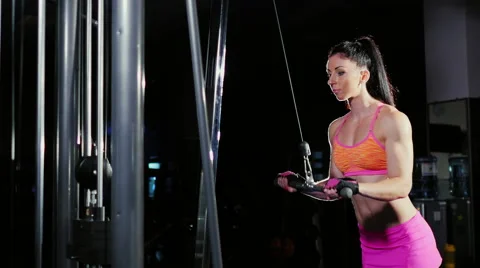 Athletic woman practicing on the simulator in the gym. Trains arm muscles Stock Footage 66261674