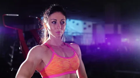 Athletic woman, a professional bodybuilder posing in front of a mirror, shows Stock Footage 66277742