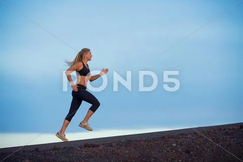 Athletic woman running jogging outside Stock Photos