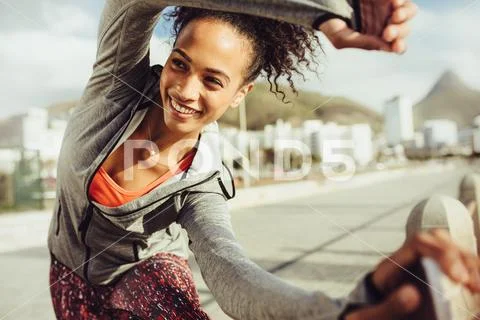 Athletic woman stretches outdoors Stock Photos