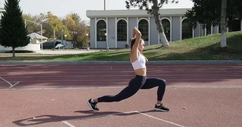 Athletic woman stretching warming up outside before workout. Young woman in Stock Footage 255517954