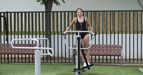Athletic woman training on a simulator in the park. Stock Footage 103200304
