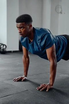 Athletic young black man doing push-ups at the gym Stock Photos