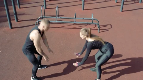 Athletic young couple doing burpie exercises outdoors Stock Footage 114563517