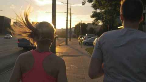 Athletic young couple running together on the urban street. Stockbeeldmateriaal 132762682