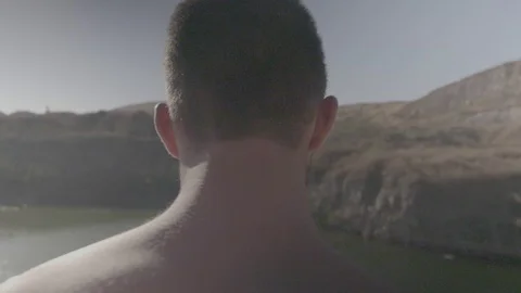Athletic young guys jumping Into pond from rock cliff slow motion Stock Footage 116066906