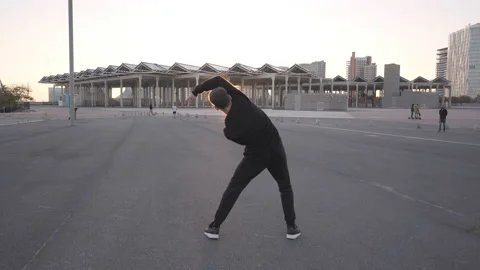 Athletic young man in black clothes dancing contemporary in an urban setting  Stock Footage 143613785